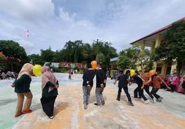 foto peserta sedang melakukan lomba pecah balon dalam kegiatan memperingati hari guru